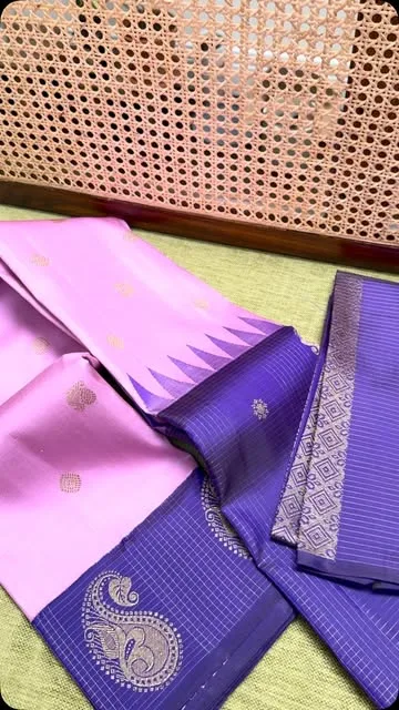 Onion pink pure silk Kancheepuram saree with a royal purple paisley-motif border, laid out to show the pallu.