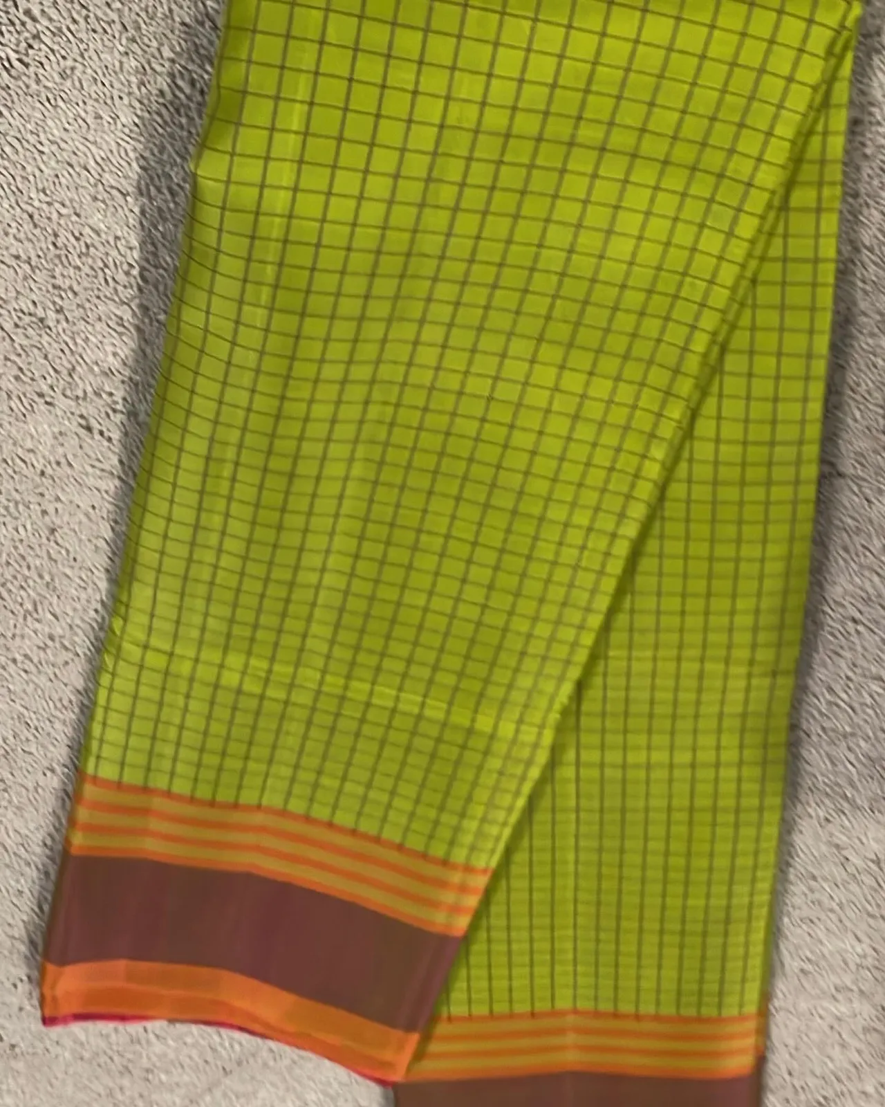 Parrot green checkered silk saree with a dark maroon and orange striped border.