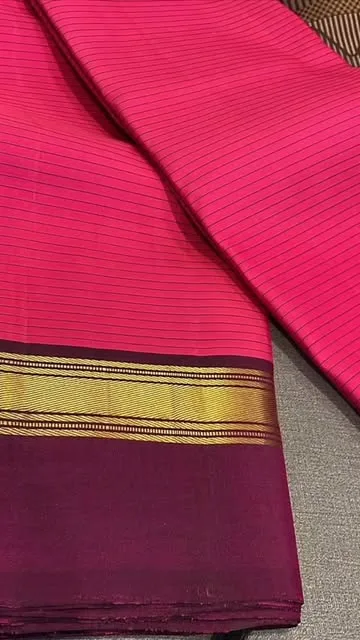 Vibrant pink silk saree with a dark pink and gold striped border.